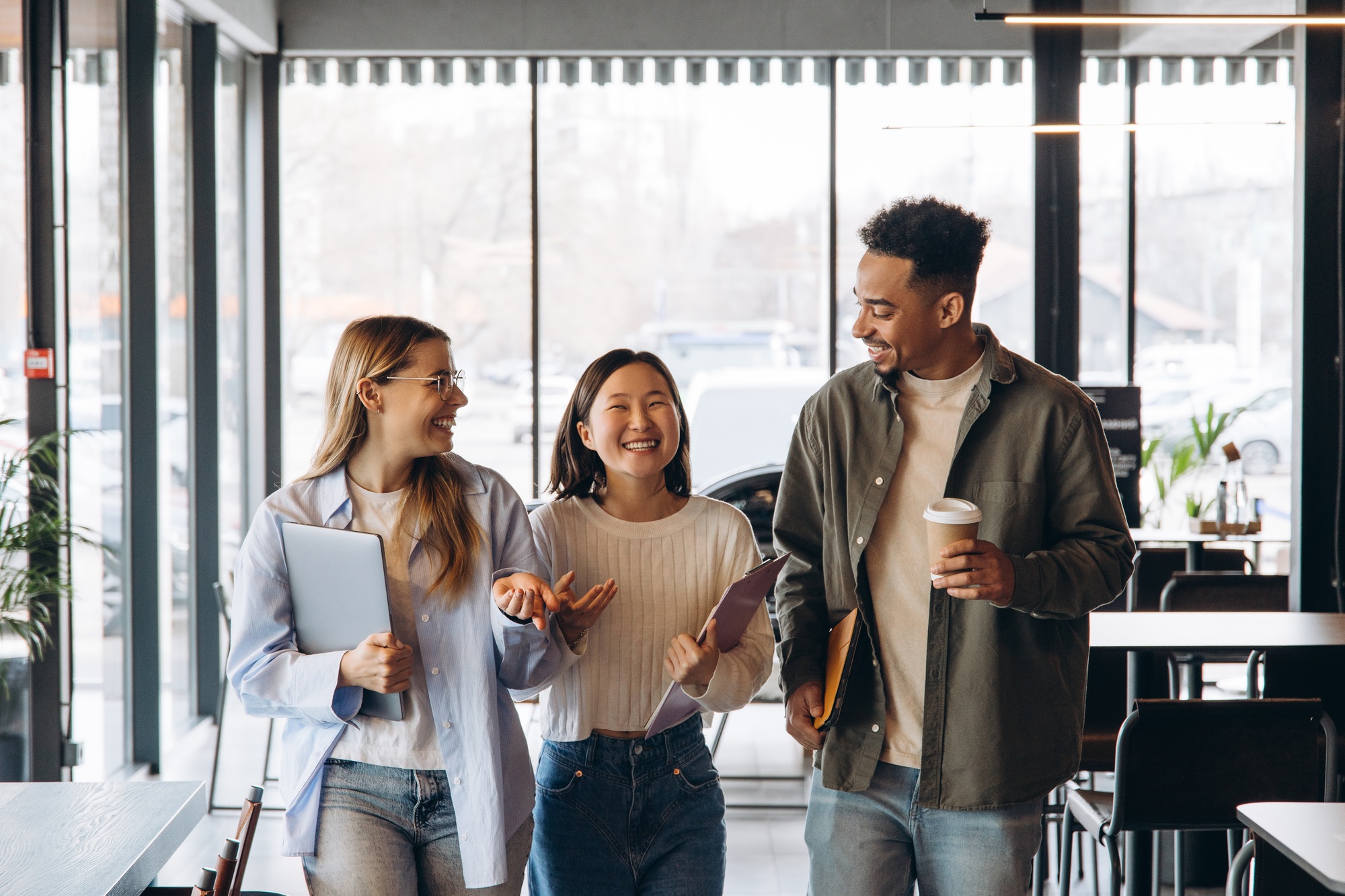Diverse university students walking and talking in cafeteria